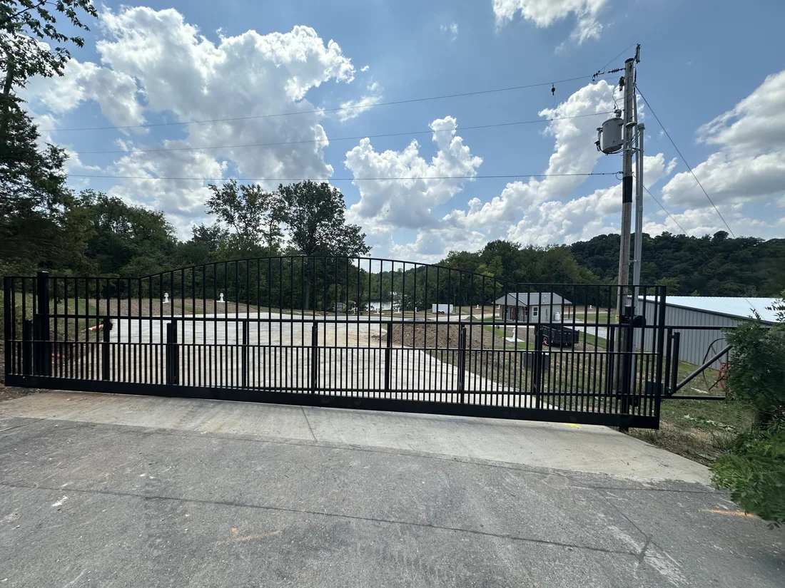 The black steel entry gate at Belle Pointe Park with sites and the cove beyond