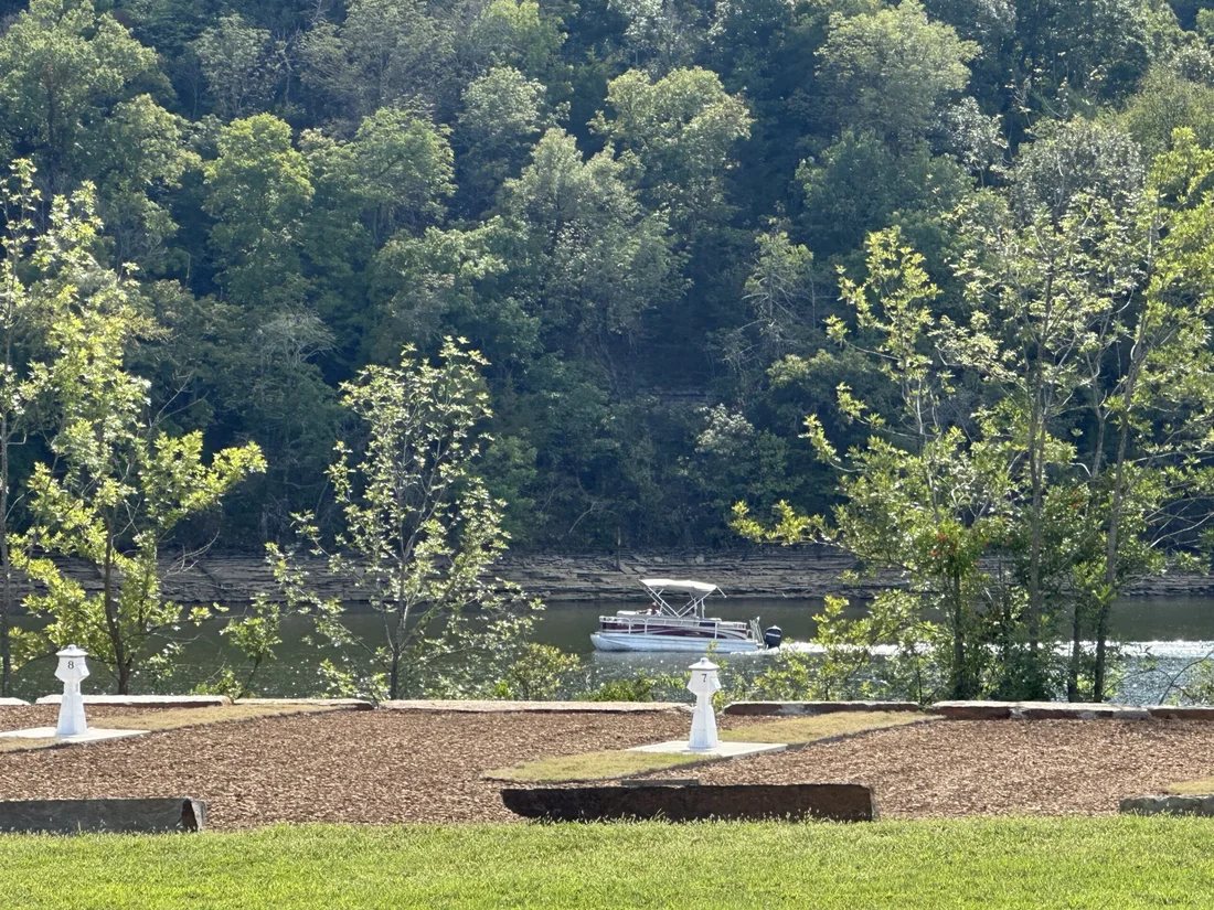 A pontoon boat cruising past the Belle Pointe waterfront sites on Beaver Lake